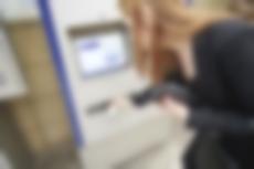 Eine Frau kauft am Ticketautomaten ein Ticket.