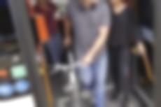 Mann steigt mit seinem Fahrrad aus einem Bus aus.