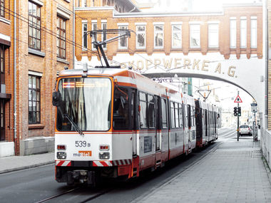 Bahn fährt unter dem Bogen der Dürkoppwerke entlang.