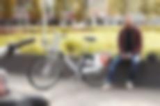 Ein Mann sitzt neben einem Siggi-Fahrrad am Kesselbrink