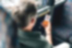 Ein Mann sitzt im Bus und hält ein Smartphone mit dem Startbildschirm des moBiel YOU App in der Hand. | Die moBiel YOU App – euer Begleiter auf allen Wegen.
