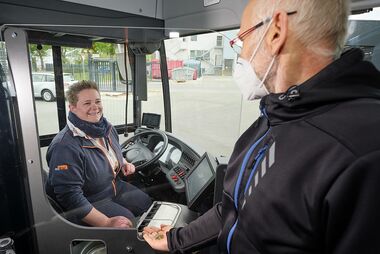Busse erhalten Trennscheibe Fahrgast beim Einstieg in den Bus. Durch eine Trennscheibe sind Fahrerin und Fahrgast geschützt.