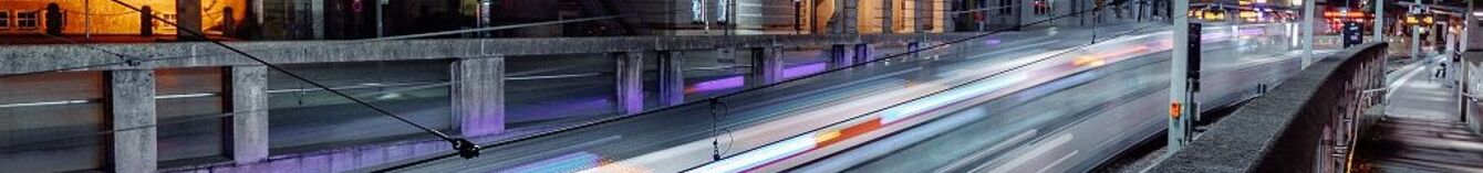 Vorbeifahrt einer Bahn am alten Rathaus bei Nacht