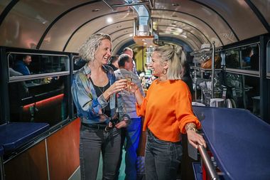 Zwei Frauen sto&szlig;en im SparrenExpress mit Getr&auml;nken an.