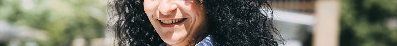 Eine Frau schaut an der StadtBahn-Haltestelle auf ihr Handy.