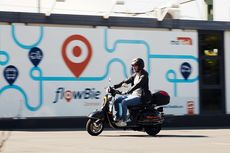 Mit Alma durch Bielefeld düsen! Ein Mann fährt auf dem Alma E-Roller an der flowBie-Zentrale in Bielefeld vorbei.