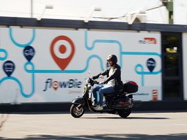 Mit Alma durch Bielefeld düsen! Ein Mann fährt auf dem Alma E-Roller an der flowBie-Zentrale in Bielefeld vorbei.