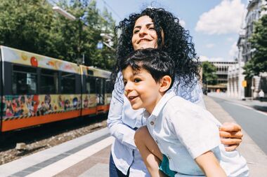 Mutter und Sohn warten am Rathaus auf die StadtBahn.
