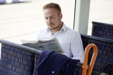 Fahrgast in der StadtBahn liest Zeitung