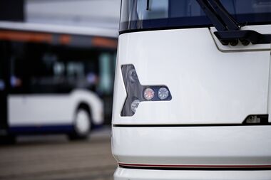 Scheinwerfer und Blinker der Vamos-StadtBahn in der Nahaufnahme, im Hintergrund ein moBiel-Bus.
