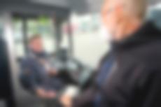 Auf dem Bild ist eine moBiel Bus-Fahrerin auf ihrem Fahrersitz zu sehen. Ein Fahrgast möchte ein Ticket kaufen. Zwischen ihnen sieht man die Trennscheibe aus Plexiglas, die beide vor der Ansteckung mit dem Coronavirus schützen soll.