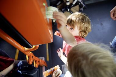 Ein Junge entwertet ein Ticket im Bus.