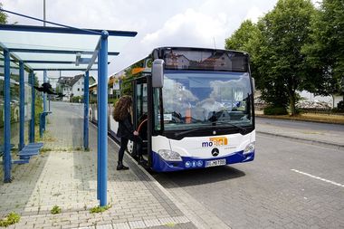 Fahrgast steigt an einer Haltestelle in den Bus ein.
